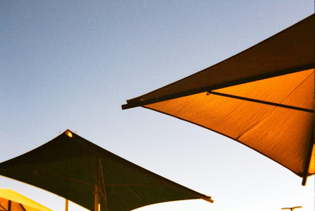 Two large sunshades against a clear blue sky